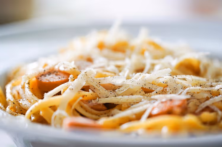 Bord pasta met kaas en stukjes worst