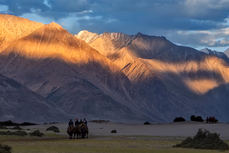Reiter in den Bergen Indiens bei Sonnenuntergang