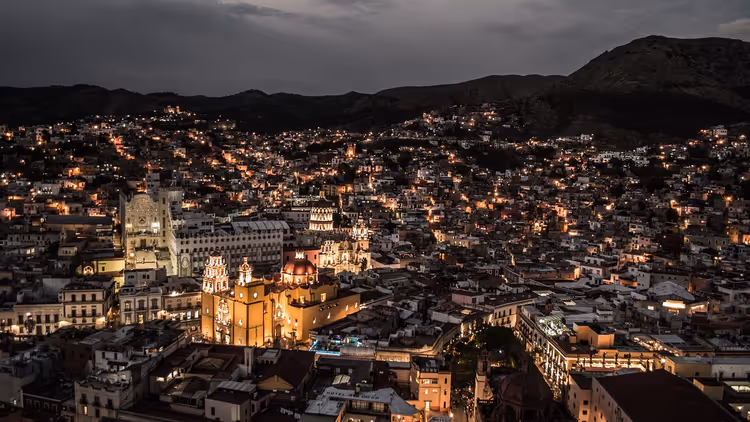 Nattutsikt over Guanajuato med opplyste kolonikirker