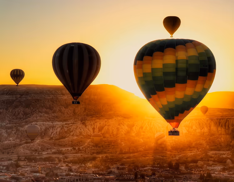 Gün doğumunda Göreme Vadisi üzerinde sıcak hava balonları