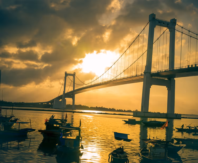 Hängebrücke in Da Nang bei Sonnenuntergang mit Booten