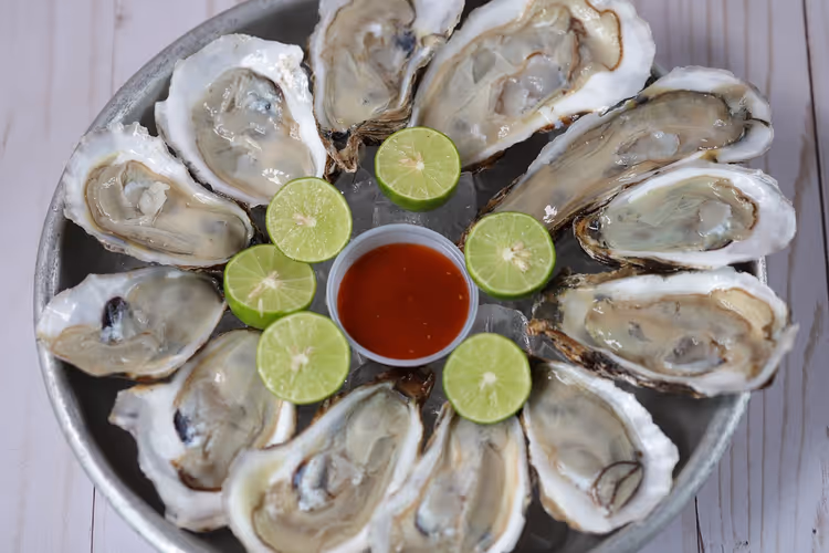 Tallerken med rå østers, lime og saus