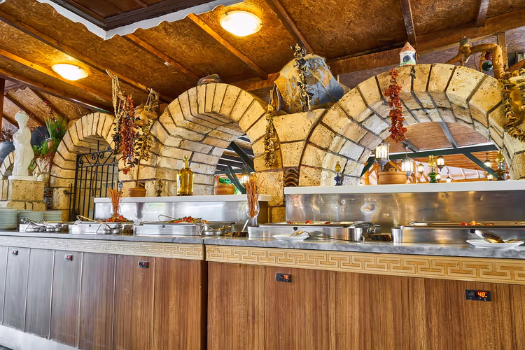 Isıtıcılı kaplar ve taş kemerler bulunan restoran büfesi