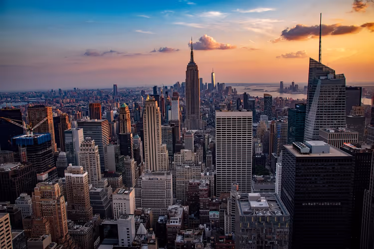Skyline von Manhattan bei Sonnenuntergang, das Empire State Building ragt über dicht stehende Wolkenkratzer, New York