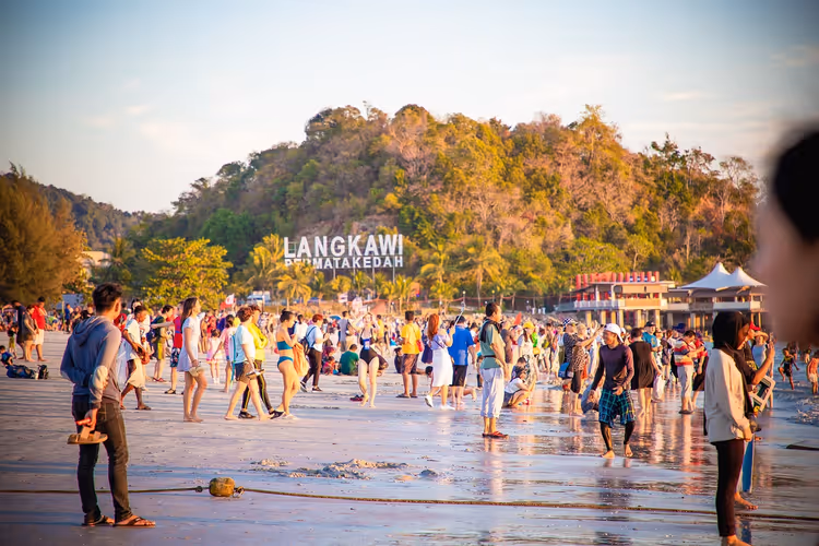 Langkawi-strand med en mengde ferierende ved solnedgang
