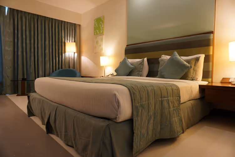Yatak ve perdelerle otel odası iç mekânı