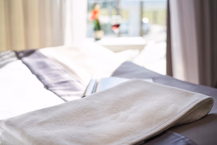 Lyst hotellrom med seng og håndklær