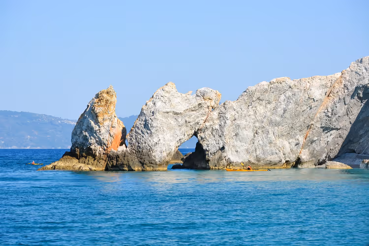 Rotsboog in turquoise zee voor de kust van Skiathos