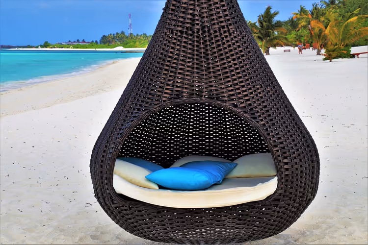 Hangende eierstoel op een strand met turquoise water