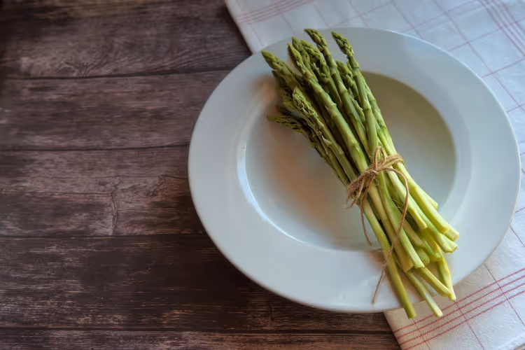Bündel dünner wilder Spargel auf einem Holztisch