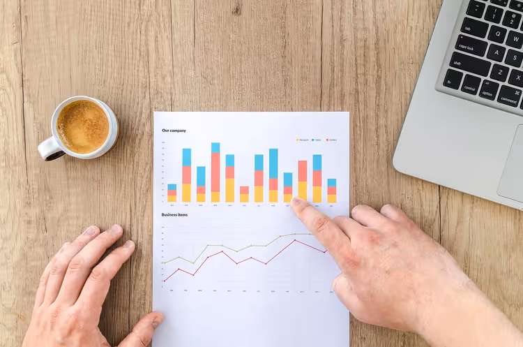Masadaki grafik ve çizelgeleri işaret eden eller