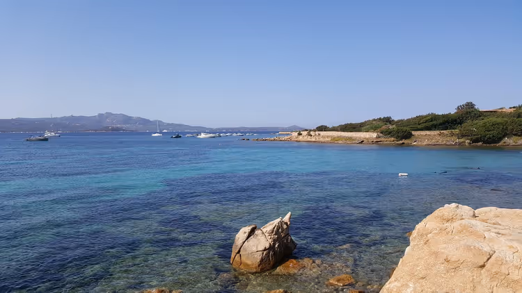 Kayalık sahil ve yatların süslediği turkuaz deniz