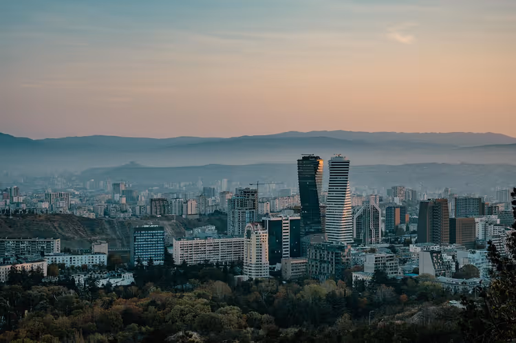 Panorama over Tbilisi med moderne høyhus i grålysningen