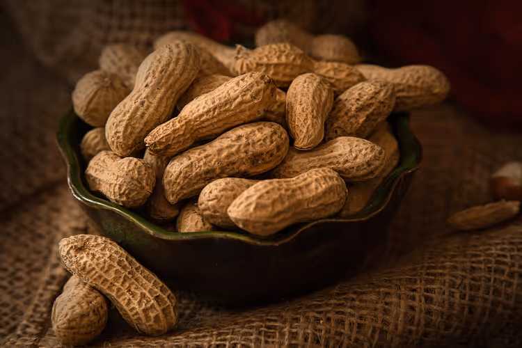 Peanøtter med skall i en bolle på jute