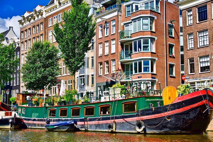 Kanal in Amsterdam mit Hausboot und Fassaden