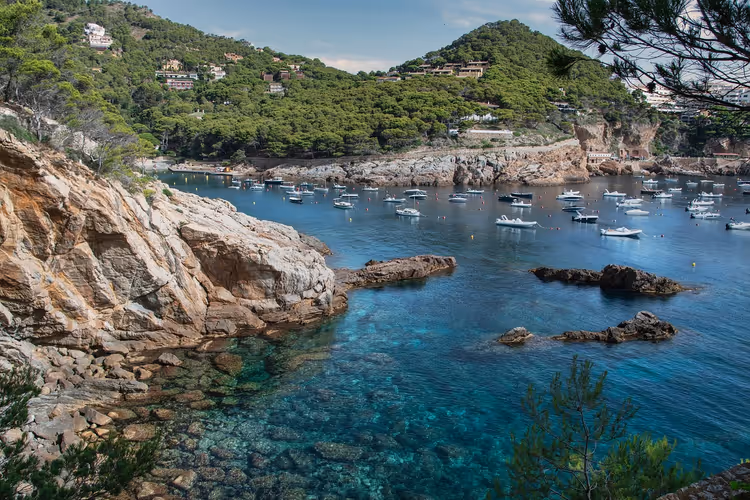 Malerische Bucht an der Costa Brava mit Booten und Klippen