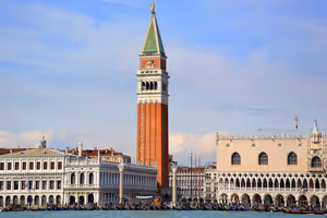Der Markusturm aus rotem Backstein über dem Dogenpalast und vertäuten Gondeln, von der Lagune von Venedig aus gesehen