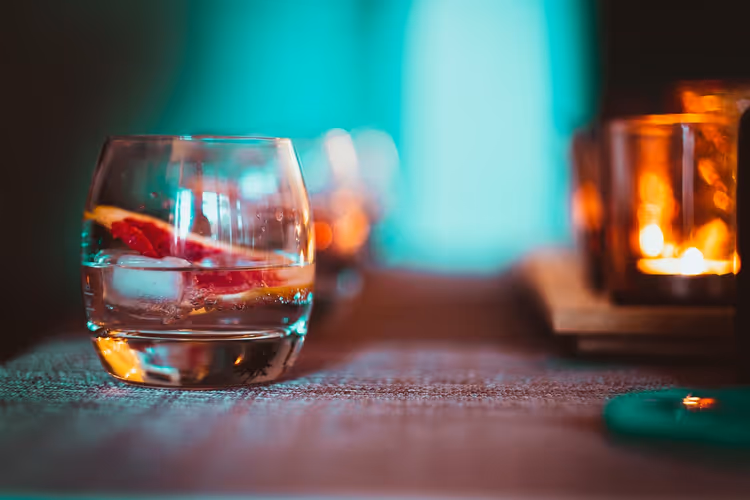 Gin tonic con una fetta di agrumi sul bancone di un bar