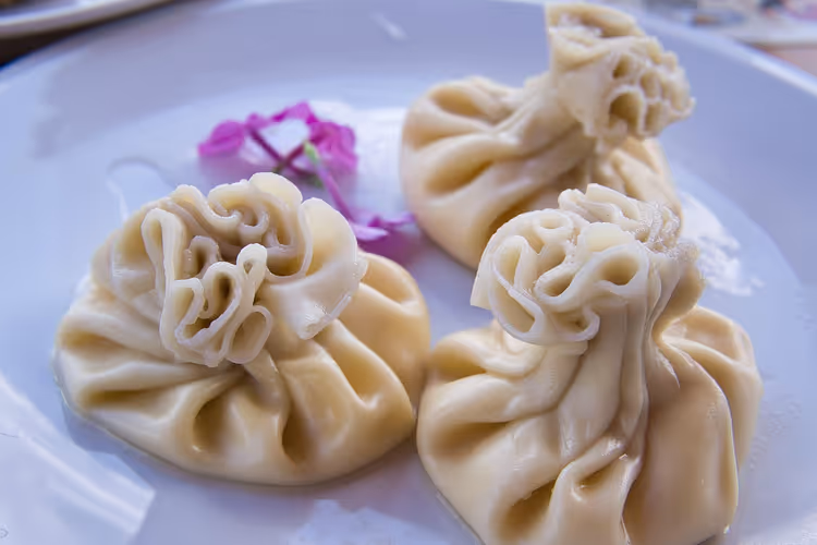 Drei Chinkali auf einem weißen Teller