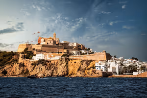 Befestigte Altstadt Dalt Vila auf Ibiza auf einem Felsen über dem Meer, mit weißen Häusern unterhalb der Mauern