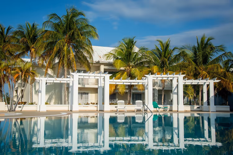 Resorthotell med basseng og palmer ved fasaden