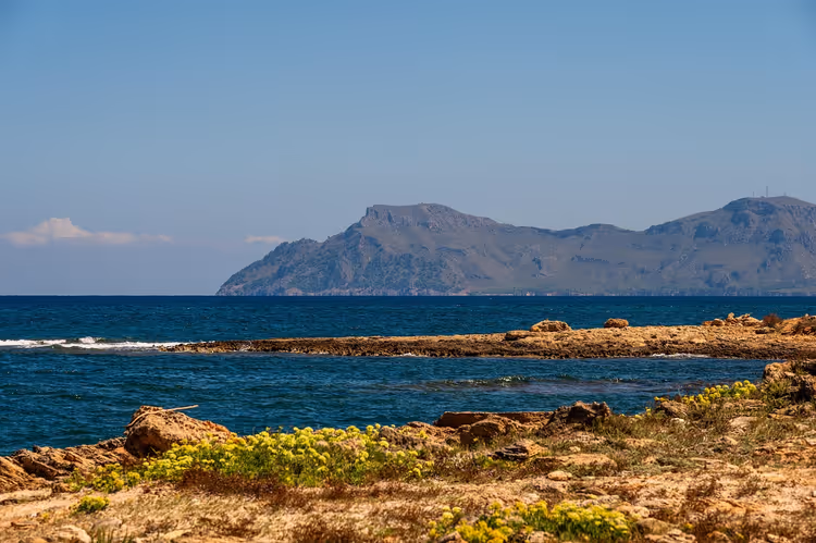 Uzakta dağlarla kayalık deniz kıyısı