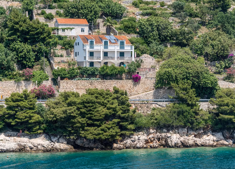 House with a tile roof on a rocky Adriatic shore