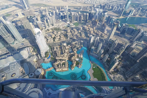 Blick von einer hohen Aussichtsplattform auf die Türme von Downtown Dubai und den türkisfarbenen Burj Khalifa Lake