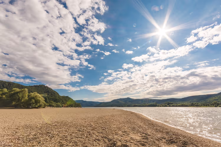 Zandige rivieroever en heuvels onder de zon
