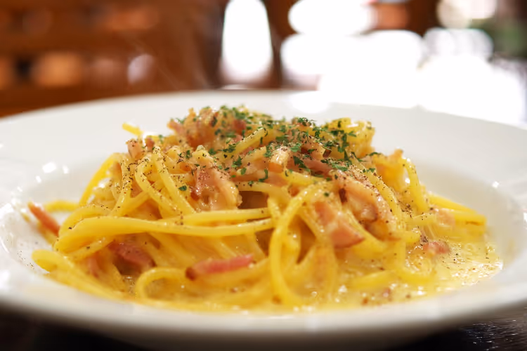 Tallerken med spaghetti carbonara med bacon og urter