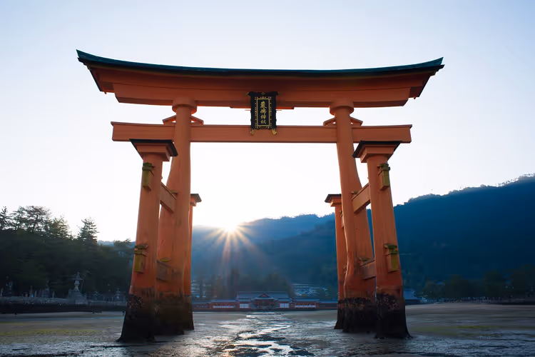 Orange Torii des Itsukushima-Schreins im Wasser bei Tagesanbruch
