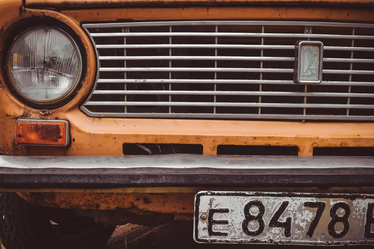Fronten av en oransje Lada med grill og frontlykt