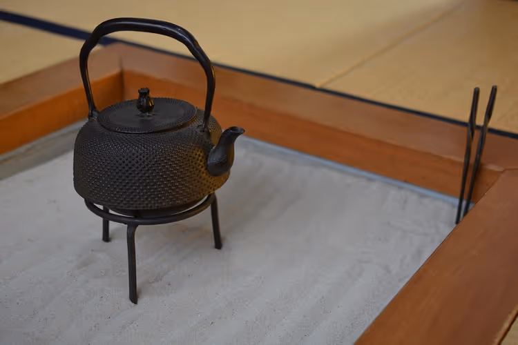 Gusseiserner Wasserkessel auf einer Feuerstelle in einem Tatami-Zimmer