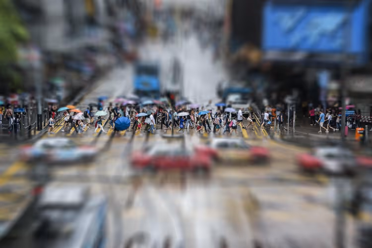 Folkemengde i en gate i Hongkong, paraplyer og taxier