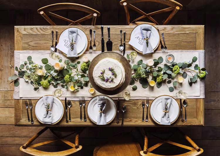 Festlig borddekking med blomster og en kake