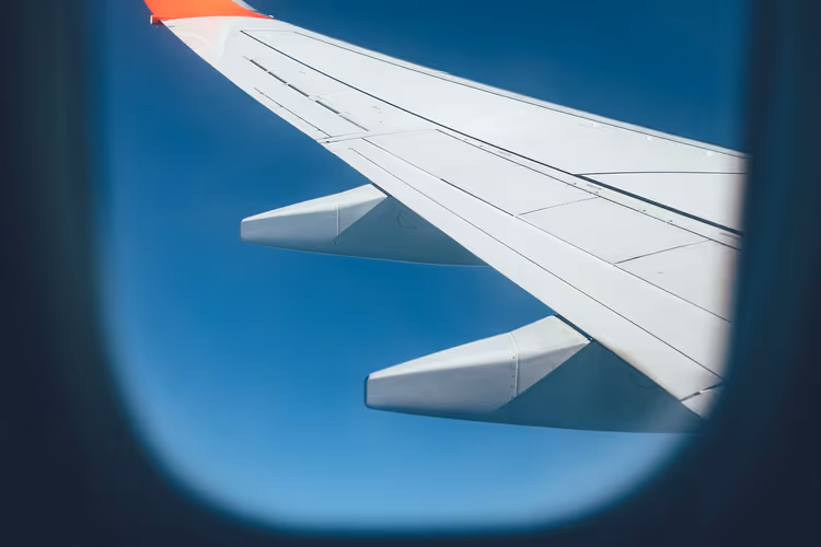 Utsikt fra flyvinduet mot vingen under flyvning