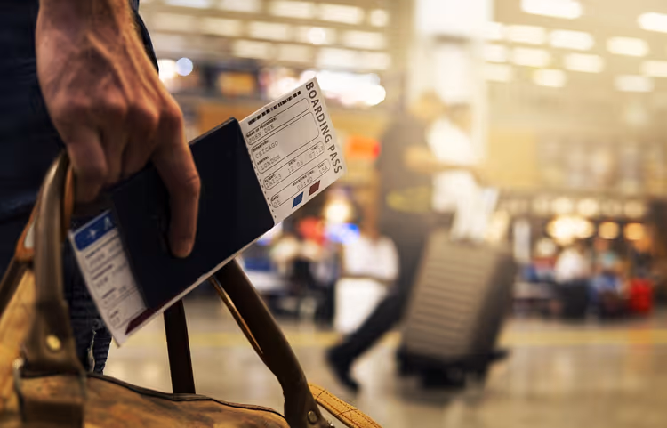 Havalimanında pasaportu ve biniş kartını tutan el