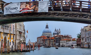 Holzbrücke über den Canal Grande in Venedig, dahinter die Kuppeln von Santa Maria della Salute und Boote auf dem Wasser