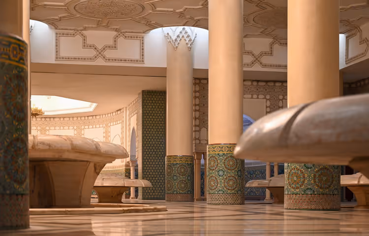 أعمدة رخامية بقواعد من الزليج ونوافير منحوتة في قاعة الوضوء بمسجد الحسن الثاني في الدار البيضاء