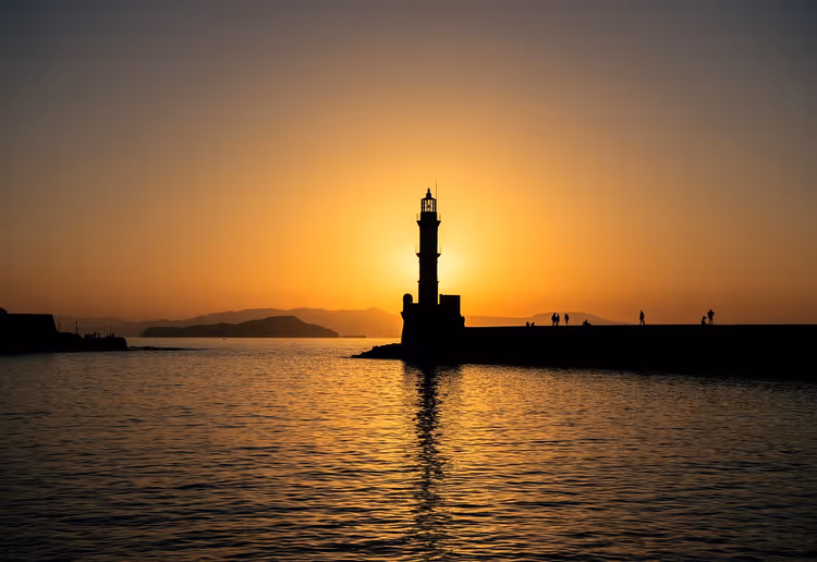 Vuurtoren in de haven van Chania tegen de zonsondergang