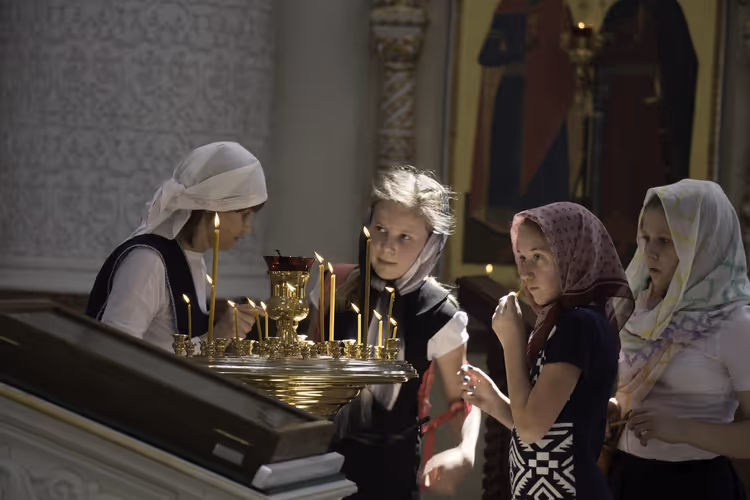 Kinder mit Kerzen in einer orthodoxen Kirche an Ostern