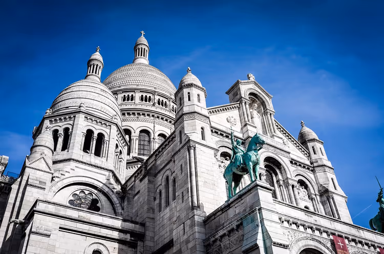 Basílica branca do Sacré-Cœur com cúpulas contra o céu