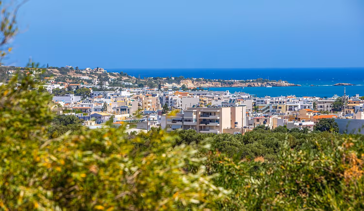 Panorama van de badplaats Chersonissos met groen en de zee