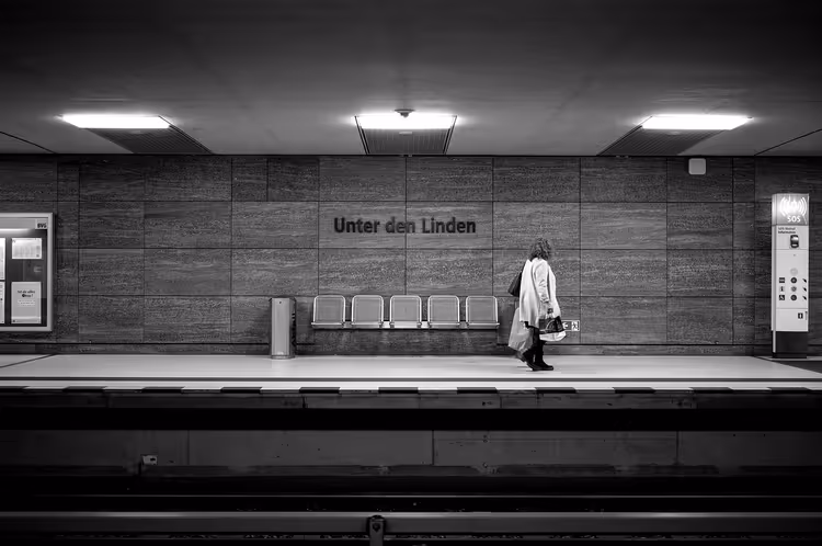 Frau geht über den Bahnsteig des U-Bahnhofs Unter den Linden in Berlin, Schwarz-Weiß-Aufnahme