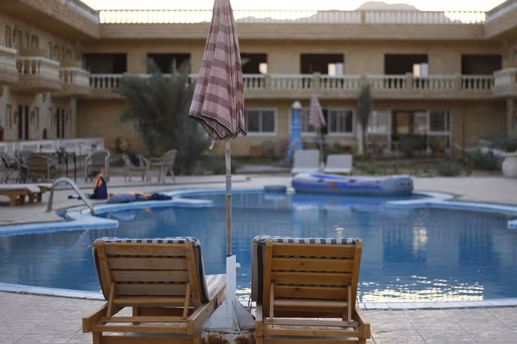Şezlonglu ve şemsiyeli otel havuzu