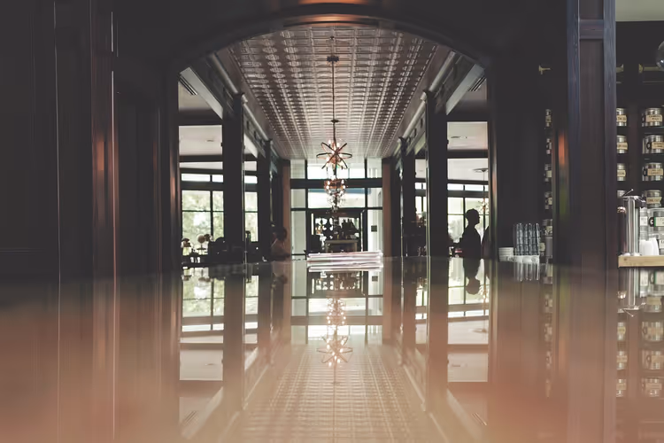 Romslig hotellobby med lysekrone og refleksjoner