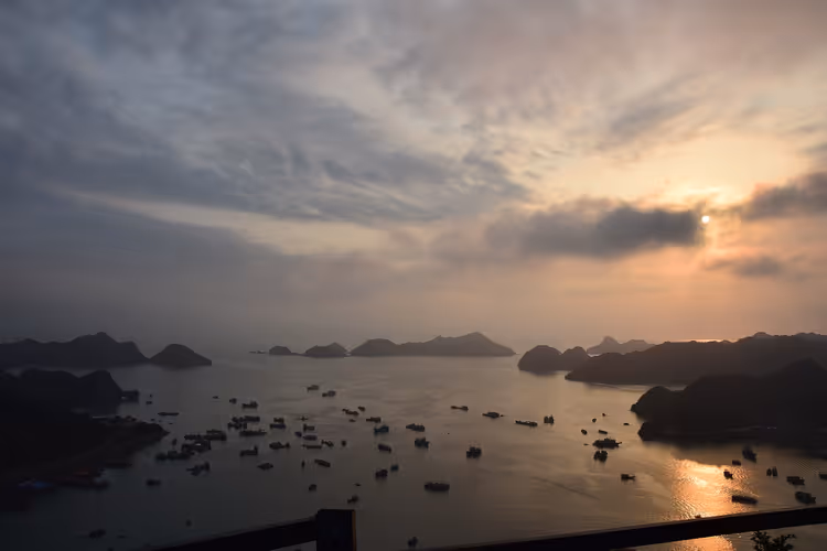 Halong Körfezi adaları üzerinde gün batımı bulutlu gökyüzü
