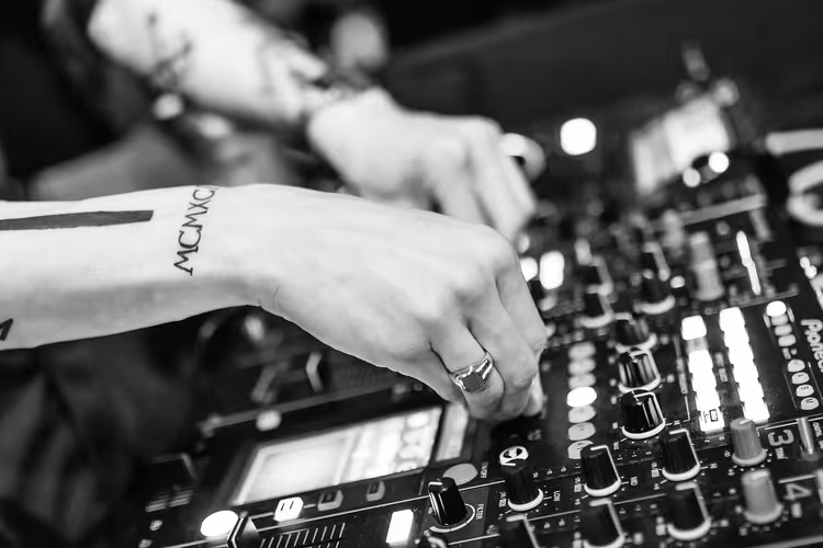 Gece kulübünde mikser başındaki DJ'in elleri