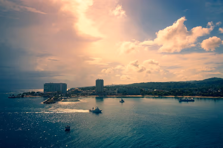 Panorama van de baai met stad en boten bij zonsondergang