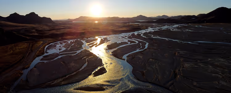 Tramonto su un fiume e le montagne in Islanda